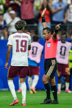 Lamine Yamal of Spain and Referee Ivan Barton