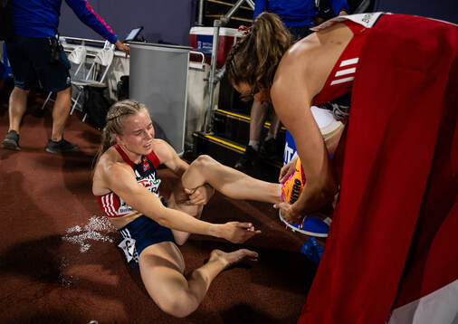 Henriette Jæger receives help taking her shoes of from her